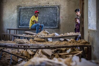 Adolescentes y niños, observan el estado de su escuela destruida en el distrito de Nuwakot, al oeste de Katmandú, Nepal.