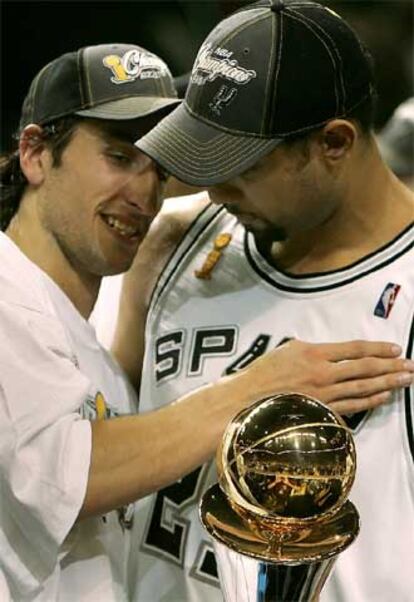 Ginobili felicita a Duncan, que sujeta el trofeo al mejor jugador de la final.