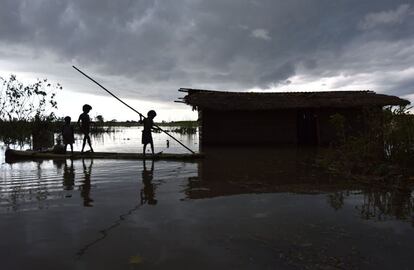 Unos niños se desplazan en una balsa hacia su casa, parcialmente sumergida a causa de las inundaciones, en la localidad de Mayong, en el distrito de Assam Morigoan, India.