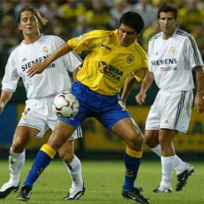 Riquelme, del Villarreal, intenta controlar el balón ante Michel Salgado (izqda.) y Figo.