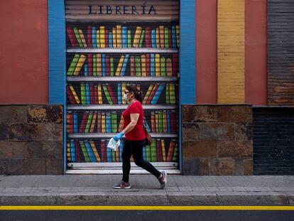 Una mujer pasa por delante de una librería cerrada en Sevilla, en el día internacional del libro.