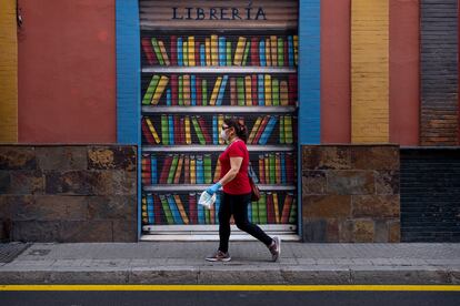 Una mujer pasa por delante de una librería cerrada en Sevilla, en el día internacional del libro.