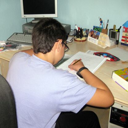 Alex hace los deberes en su escritorio, en su casa, ayer por la tarde.