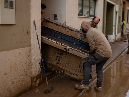 En la imagen, Lupe Murcia y Miguel Ramírez retiran de su casa con la ayuda de otra persona un piano inutilizado por el agua el pasado 5 de noviembre. El piano, que ahora lo utilizaba su hija, lo compró ella cuando era una estudiante.