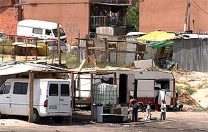 Habitantes del poblado chabolista de Las Mimbreras, en Latina, frente a uno de los chamizos, horas después del tiroteo mortal.