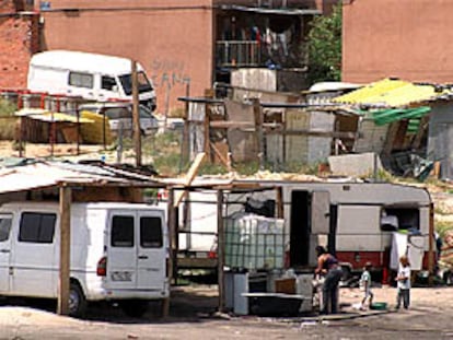 Habitantes del poblado chabolista de Las Mimbreras, en Latina, frente a uno de los chamizos, horas después del tiroteo mortal.