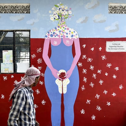 Un hombre camina junto a un mural que homenajea el Día de la higiene menstrual en Guwahati (India)