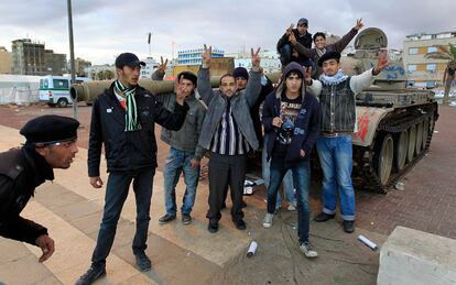 Jóvenes sobre un carro de combate abandonado junto al puerto de Bengasi celebran la victoria en la ciudad de Zauiya.