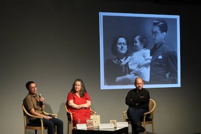 Emiliano Delgadillo, Verónica Loera y Eduardo Vázquez Martín conversan durante la presentación de la monografía 'Las tendencias sociales de Diego Rivera' de Efraín Huerta.  Detrás de ellos, una fotografía del poeta y su familia.