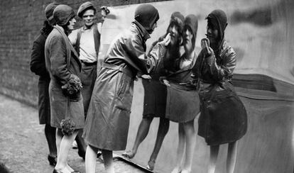 Unas chicas londinenses se miran en un espejo distorsionado. Fotografía de 1930.