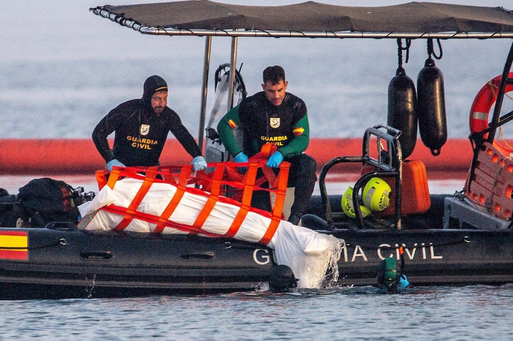 Guardia Civil officers recover the body of a migrant from the water in the Spanish enclave of Ceuta, Saturday, Aug. 1, 2026. (AP Photo/Antonio Sempere)