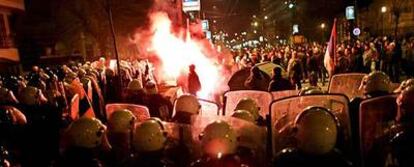 Policías antidisturbios contienen a los manifestantes serbios que lanzan antorchas contra la Embajada de Estados Unidos en Belgrado.