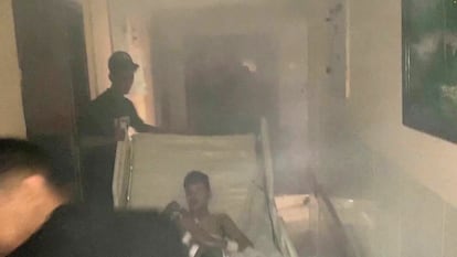 Medics move a patient through the smoke-filled corridors inside Al Shifa hospital following an Israeli raid, amid the ongoing conflict between Israel and the Palestinian group Hamas, in Gaza City, November 15, 2023.