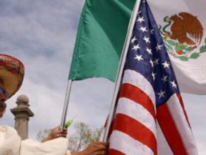 Un mexicano con una bandera de su pa&iacute;s y otra de EE UU, en Denver.