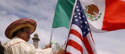 Un mexicano con una bandera de su pa&iacute;s y otra de EE UU, en Denver.