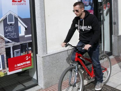 Un joven pasa delante de una sucursal de Mapfre, en Madrid.