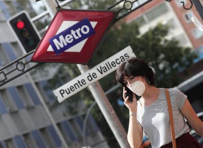 Una mujer pasea al lado del metro de Puente de Vallecas.