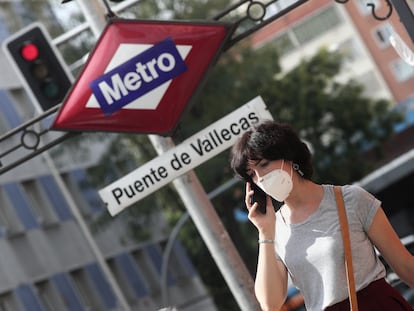 Una mujer pasea al lado del metro de Puente de Vallecas.