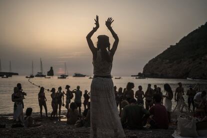 Una mujer baila al atardecer en la cala Benirrás.