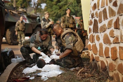 Médicos franceses intentan salvar a un hombre con la garganta cortada después que las milicias musulmanas 'Seleka' evacuaron el Camp de Roux centro de Bangui, República Centroafricana. 