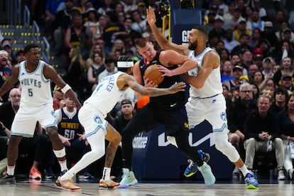 Rudy Gobert y Nickeil Alexander-Walker intentan quitar la pelota a Nikola Jokic.