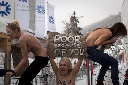 Manifestantes ucranias en 'topless' subidas a una valla del centro de congresos donde se celebra el Foro Económico Mundial en Davos, Suiza.