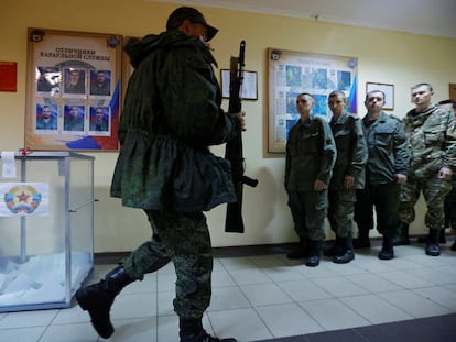 Un militar de la autoproclamada República Popular de Lugansk camina con un rifle después de votar en la consulta para unirse a Rusia, este viernes.