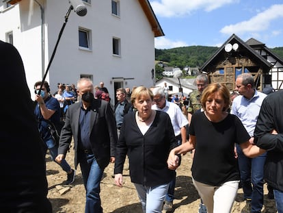La canciller alemana, Angela Merkel (izquierda), toma de la mano a la presidenta de Renania-Palatinado, Manu Dreyer, durante la visita a Schuld, el pueblo más afectado por las inundaciones.