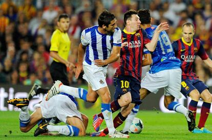 Messi, entrado por varios jugadores de la Real.