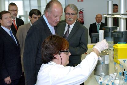 El rey Juan Carlos observa a una operadora del centro de I+D de Almirall en Sant Feliu de Llobregat.