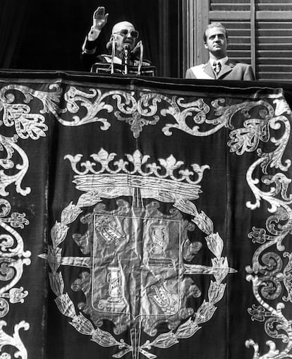 El Jefe del Estado, Francisco Franco (izquierda), acompañado del príncipe Juan Carlos de Borbón, corresponde a los vítores y aplausos de la multitud desde el balcón principal del Palacio de Oriente (Madrid), en su última aparición pública.