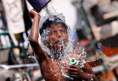 Un niño se baña en un día caluroso en una zona de tugurios en Nueva Delhi, India.