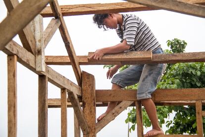 Mjane colabora en la reconstrucción de su propia vivienda con la ayuda de un par de carpinteros. Kananga, Leyte.