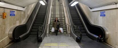 Una mujer baja cargada en la estación de Avenida de América, con las escaleras mecánicas rotas.