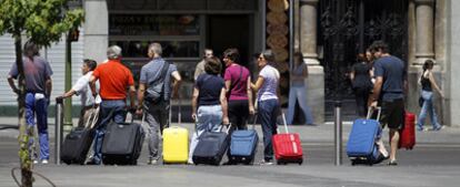 Un grupo de turistas cruzaba ayer por la mañana con sus maletas un paso de peatones en la Gran Vía.