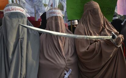 Mujeres paquistaníes con burkas sostienen una espada en señal de protesta contra los dibujos de Mahoma que publicó la revista francesa 'Charlie Hebdo', en Lahore, Pakistán.