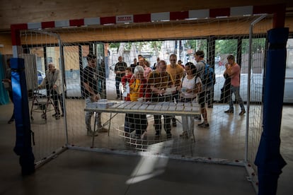 Votantes recogen las papeletas a su llegada al centro electoral, este domingo. 