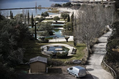 La zona de piscinas y playa artificial con las obras del hotel paralizadas a la derecha y el pantano de Valdecañas al fondo.