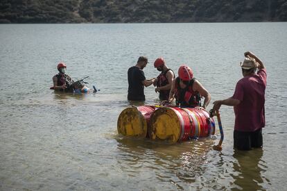 Los bomberos de la Diputación de Teruel protagonizaron la inmersión del cofre, que primero entró en las aguas del pantano de Lechago sobre unos bidones.