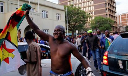 Un hombre celebra la dimisión de Robert Mugabe como presidente en las inmediaciones del Parlamento en Harare (Zimbabue).