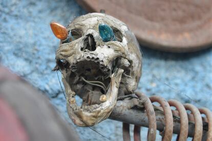 In this April 6, 2016 photo, a sculpture made out of industrial junk and topped with a human skull with Christmas lights sticking out of its eye sockets stands at an open-air museum and art workshop off a trash-strewn street cutting through some of the poorest neighborhoods in Port-au-Prince, Haiti. The site is in the yard of a founding member of a loose collective of Haitian artists called Atis Rezistans who have become celebrated in the international art world by creating sculptures out of scrapped car parts, old wood, discarded toys and even human skulls found scattered outside crumbling mausoleums. (AP Photo/David McFadden)