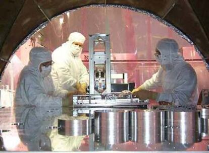 Tres expertos realizan ajustes en el detector de ondas gravitacionales LIGO en EE UU.
