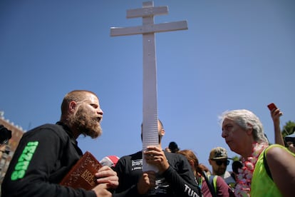 Un hombre sostiene una cruz y libros religiosos ante los participantes en la marcha del Orgullo en Budapest, este sábado.