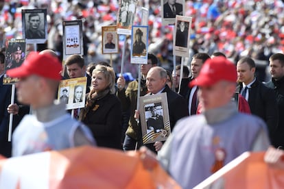 El presidente ruso, Vladimir Putin, porta el retrato de un familiar, soldado en la Segunda Guerra Mundial, durante el desfile del Día de la Victoria. 