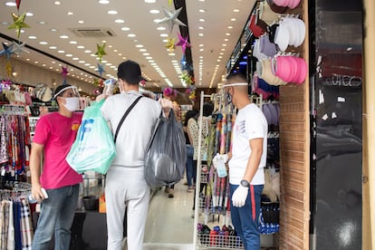 Tres personas en un comercio en el centro de São Paulo, a principios de junio.