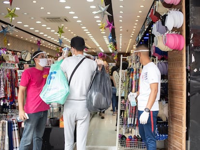 Tres personas en un comercio en el centro de São Paulo, a principios de junio.