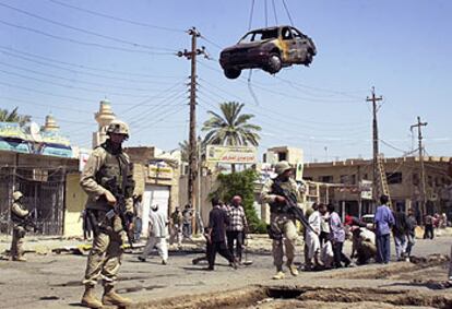Soldados de EE UU vigilan en Hilla, 100 kilómetros al sur de Bagdad, el lugar del atentado del sábado.