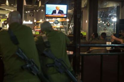 Soldados israelíes miran por televisión un discurso de Benjamin Netanyahu después del alto el fuego.