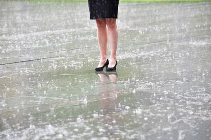 Un miembro del equipo de protocolo espera bajo la lluvia torrencial la llegada de los participantes en una reunion del G20, en la Cancillería de Berlín, Alemania.