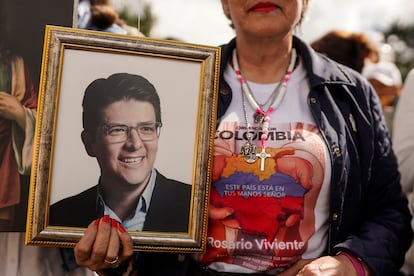 Una mujer muestra una imagen del político Miguel Uribe Turbay.